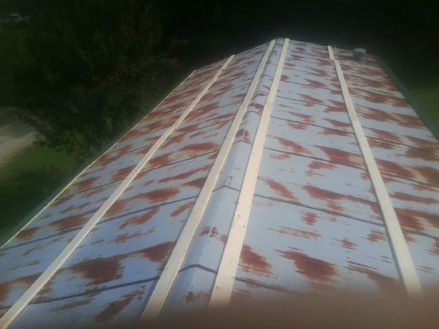 Rusted metal roof panels with new wood purlins before replacement — Storm Damage Roof Repair in Southern Pines by Roofing Brothers