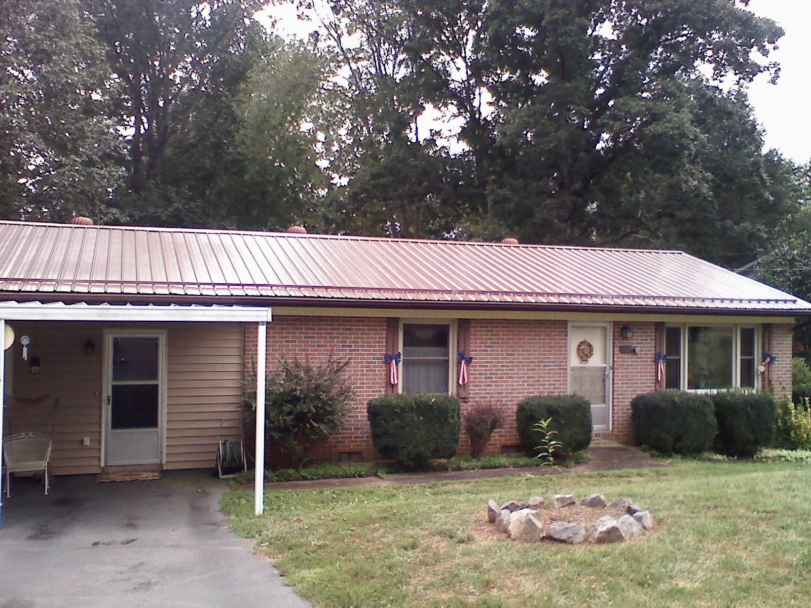 Bronze metal roof and carport on a brick ranch home — Roof Repair work by our crew in Southern Pines