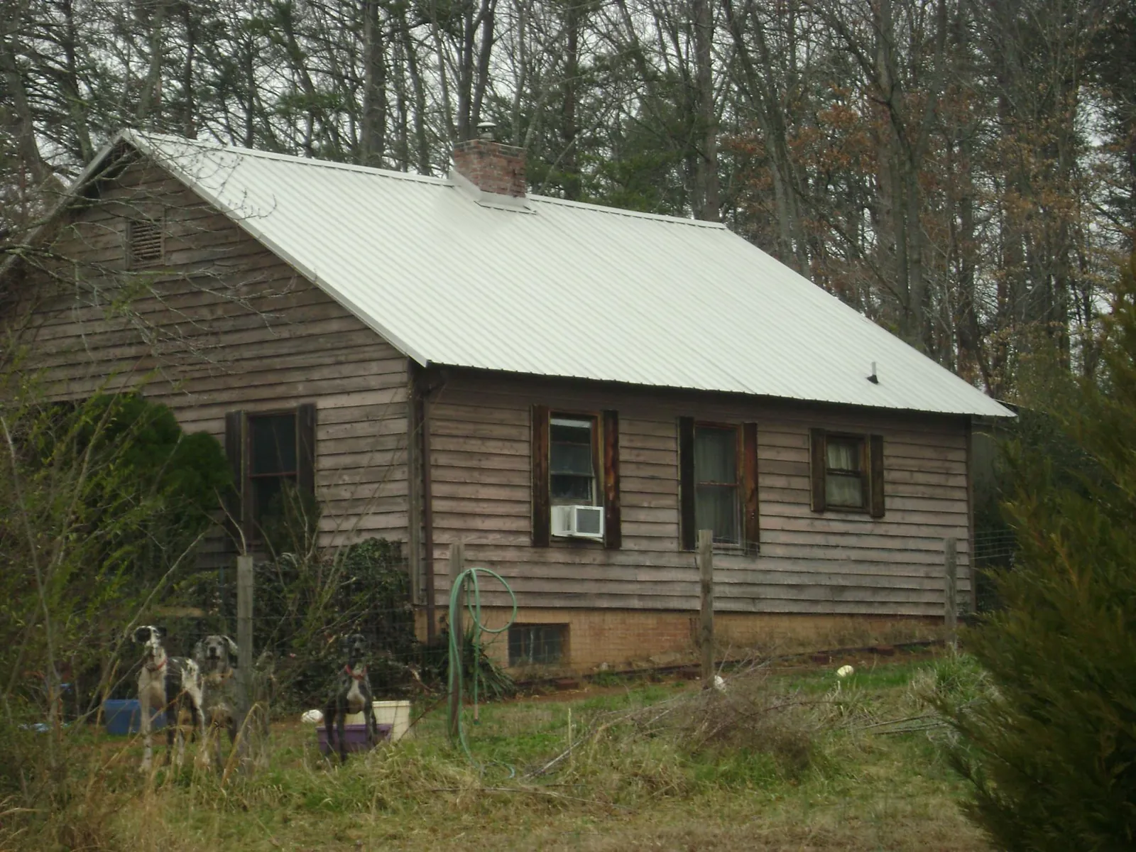 White metal roof on an old wood sided farmhouse, from a Metal Roof Installation job in Southern Pines